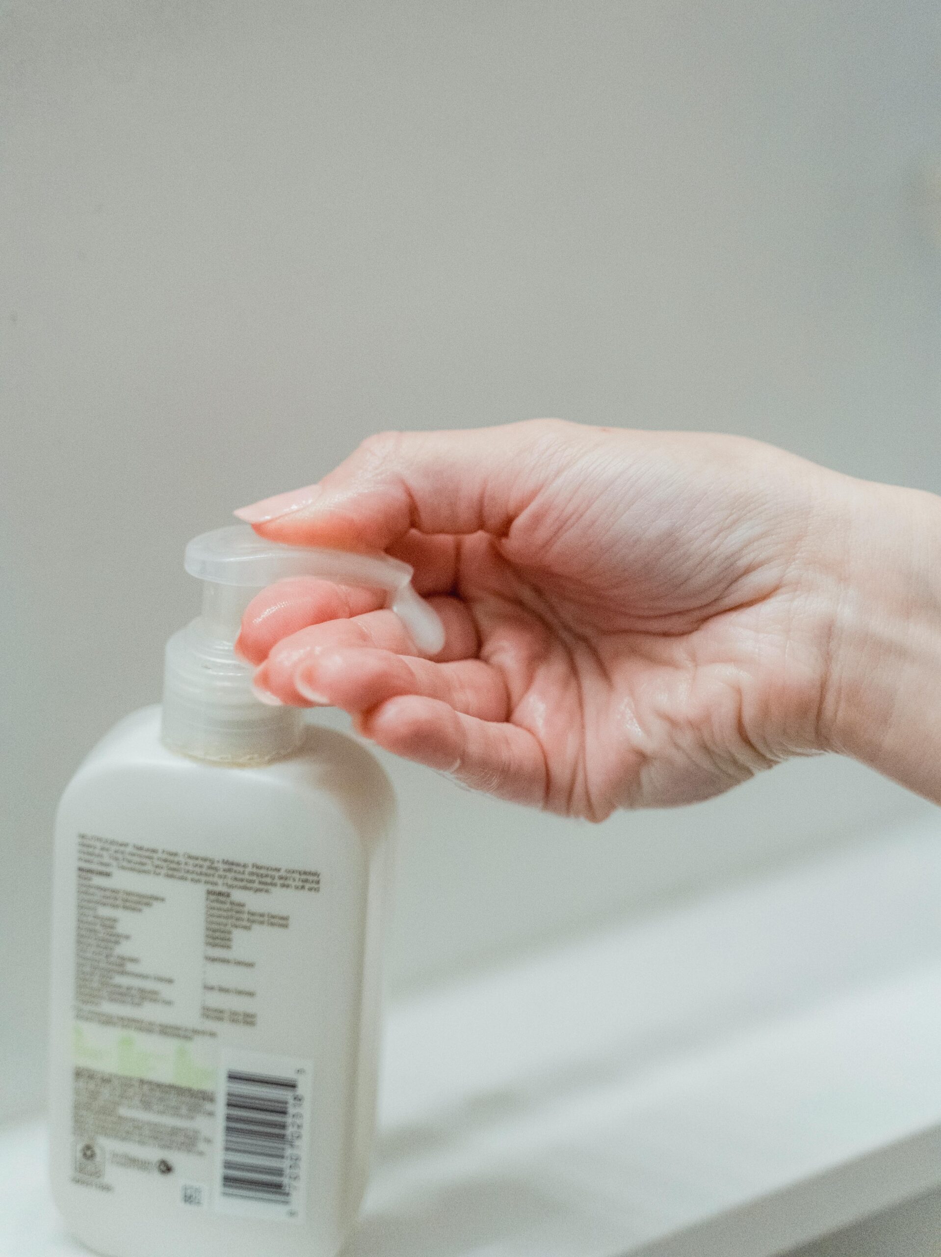 A close-up of a hand dispensing soap from a bottle, showcasing hygiene and cleanliness concepts.